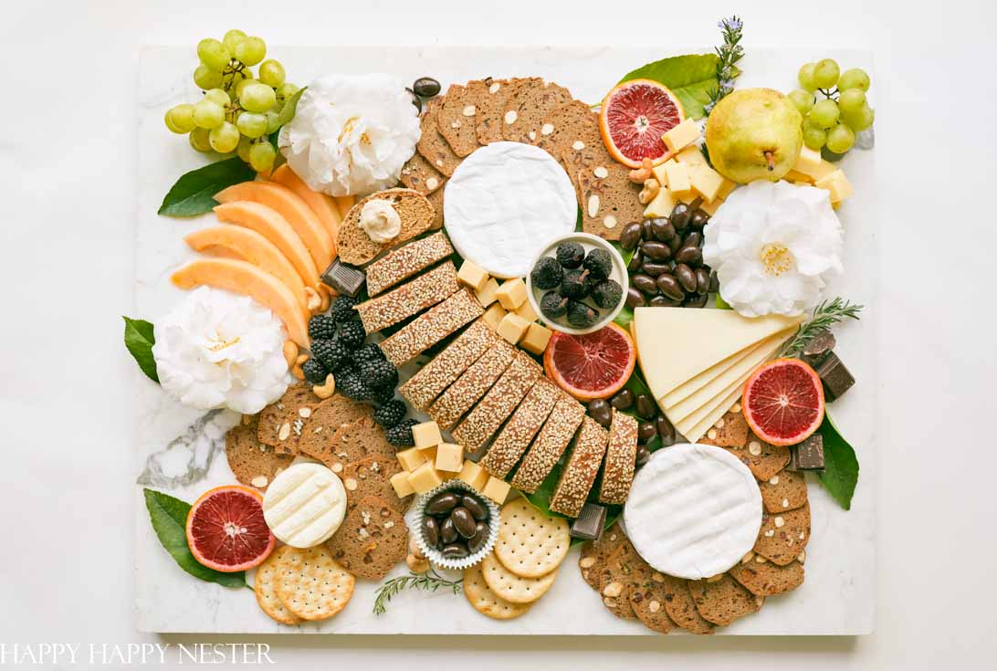 This impressive Charcuterie Board is elegantly styled with delicious cheeses, slices of bread, fruit, and rich chocolates. This epic appetizer will wow your family and friends. Learn how to create this amazing snack.