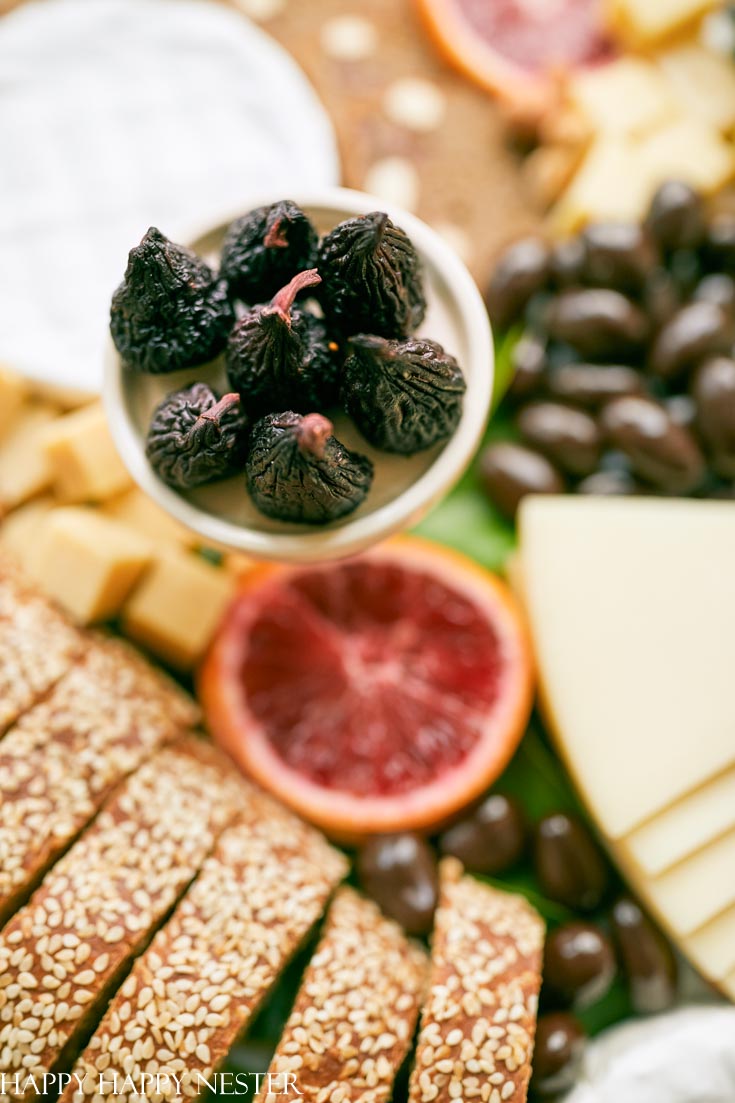 This Charcuterie Board tutorial will help you design your next appetizer. Roundup your favorite crackers, slices of bread, fruits, cheeses, and chocolates to create this platter of yummy appetizers. In no time, you'll have the best ever charcuterie board to serve to family and friends. #charcuterieboard #appetizers