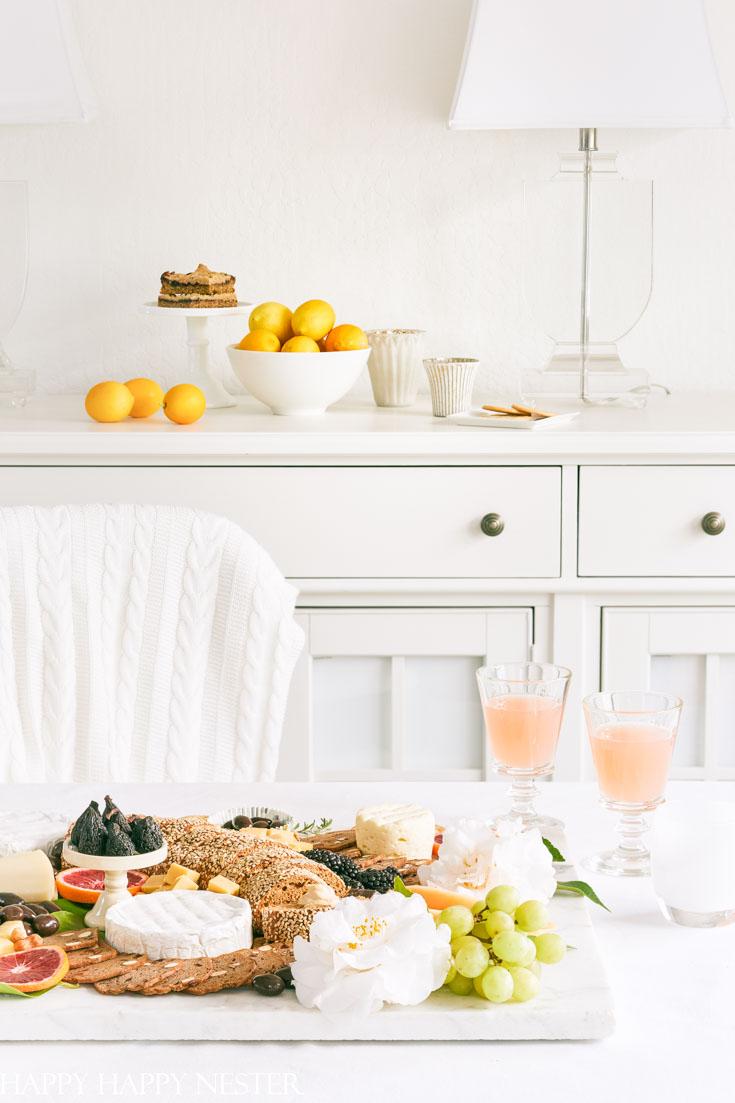 This impressive Charcuterie Board is elegantly styled with delicious cheeses, slices of bread, fruit, and rich chocolates. This epic appetizer will wow your family and friends. Learn how to create this amazing snack.