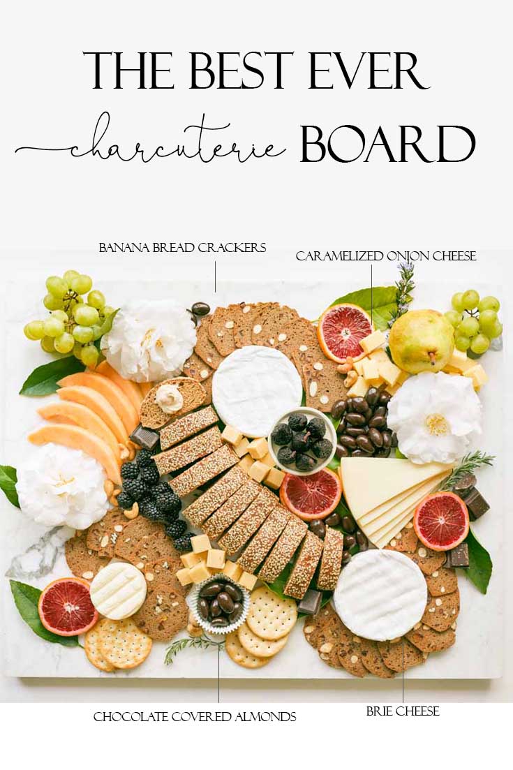 This impressive Charcuterie Board is elegantly styled with delicious cheeses, slices of bread, fruit, and chocolates. This epic appetizer will wow friends. #charcuterieboard