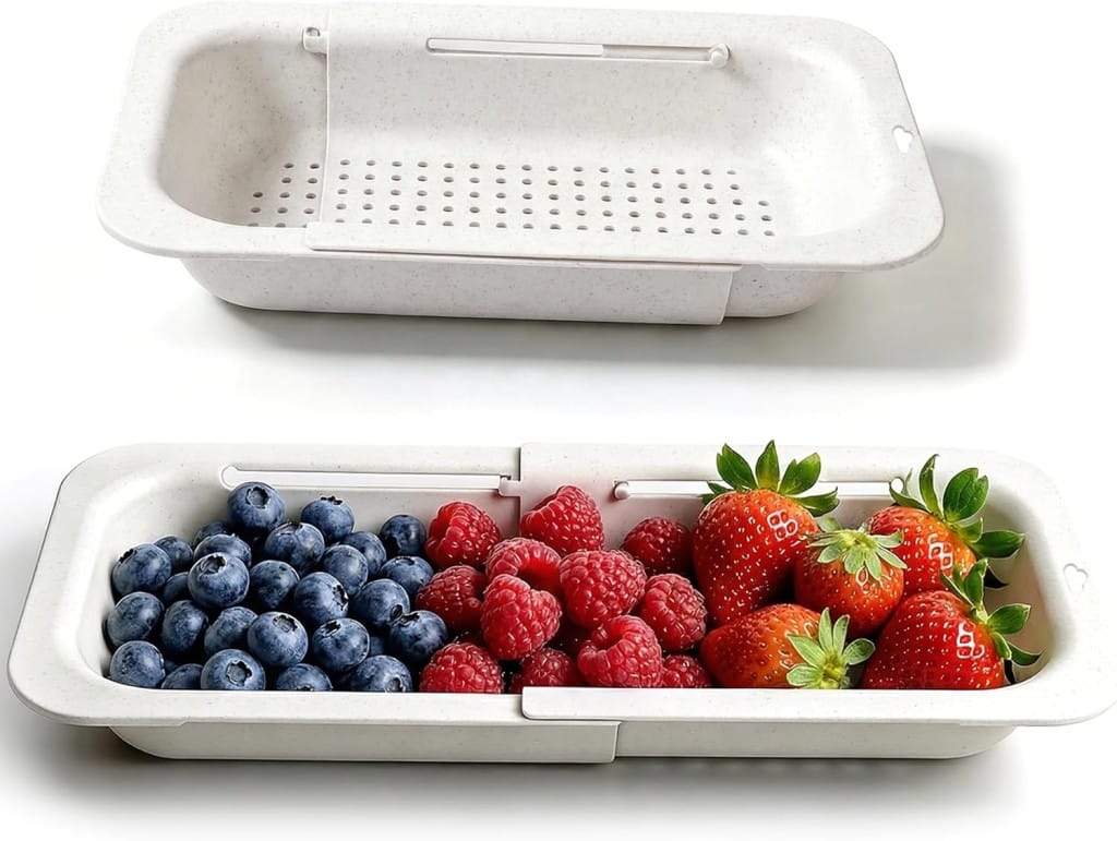 Two white, rectangular, extendable colanders. One is empty and upright, showing drain holes and handles. The other holds fresh blueberries, raspberries, and strawberries—perfect for mixed berry dessert recipes.