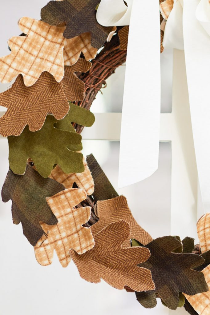 Fall grapevine wreath with plaid fabric leaves and a cream ribbon