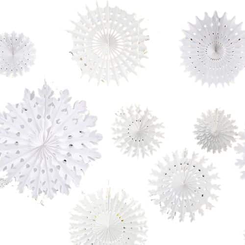 Several white, intricately cut paper snowflakes and circular fans of varying sizes are displayed against a plain white background, creating a festive and delicate appearance reminiscent of ornaments adorning a red and white Christmas tree.