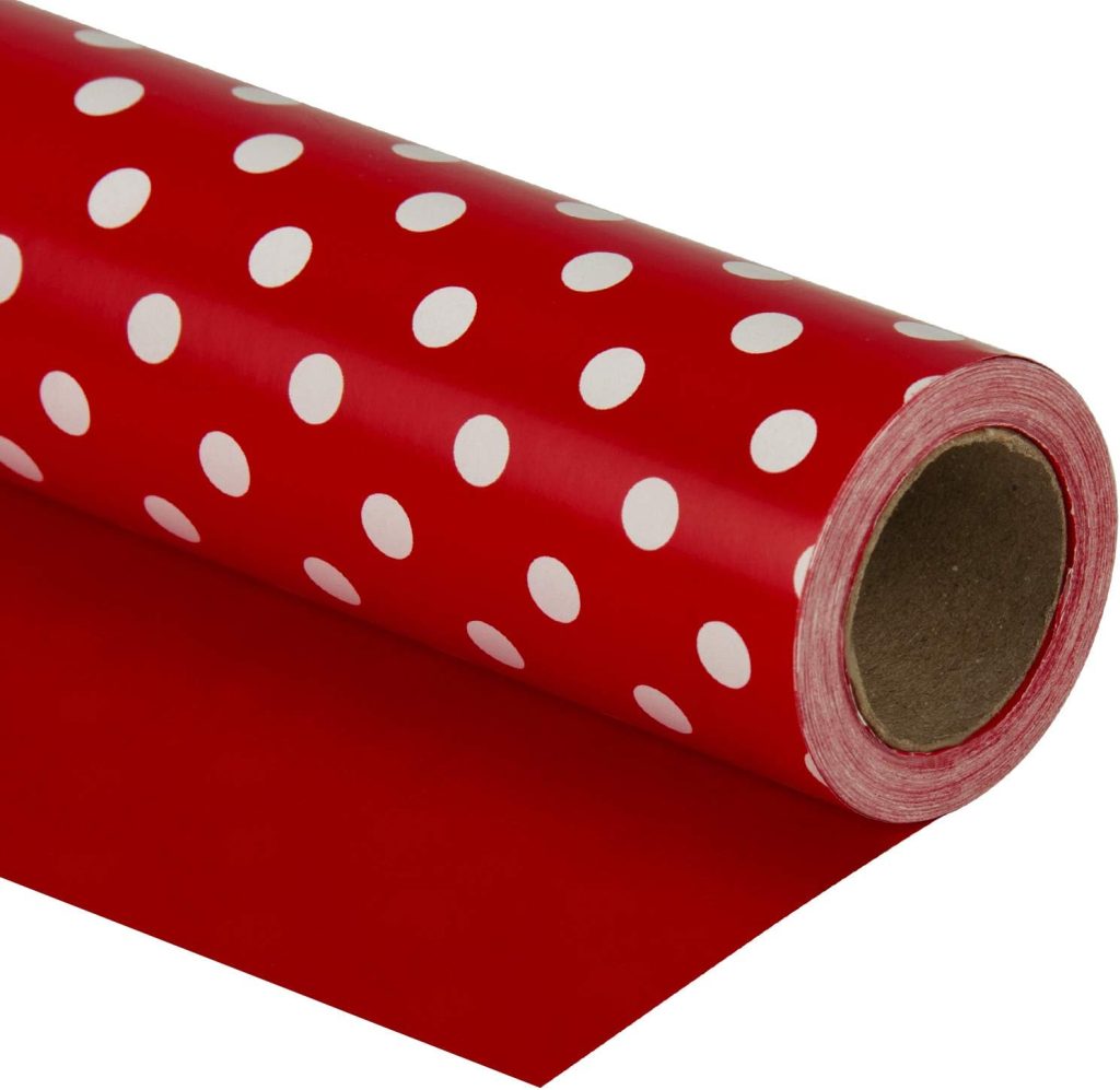 A roll of red wrapping paper with white polka dots, partially unrolled to show the pattern—perfect for wrapping gifts under your red and white Christmas tree.