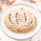 Mini pumpkin hand pie with icing drizzle on a white cake stand