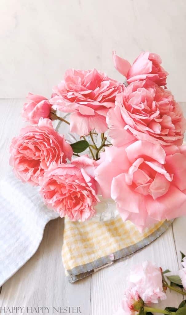 photo showing how to create a peony arrangement. This step has pink roses in a vase.