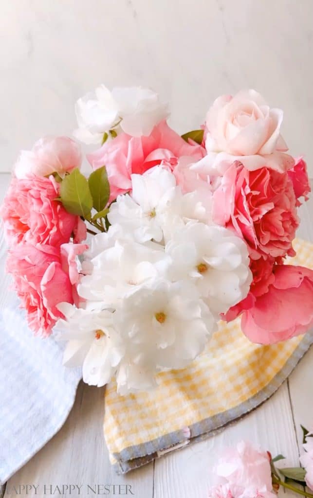 this how to photo shows peonies, white and pink roses in a vase.