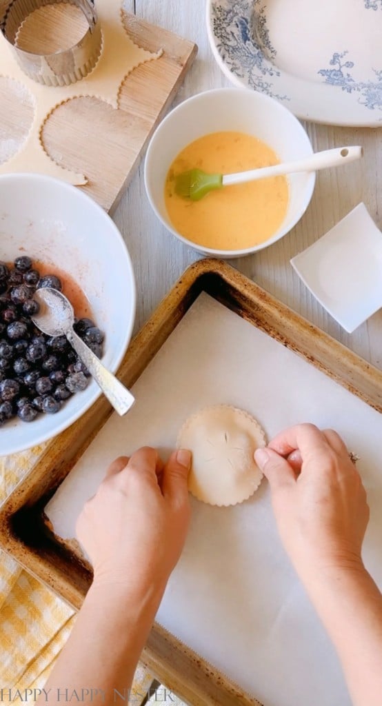 crimping the edges of a small blueberry pie