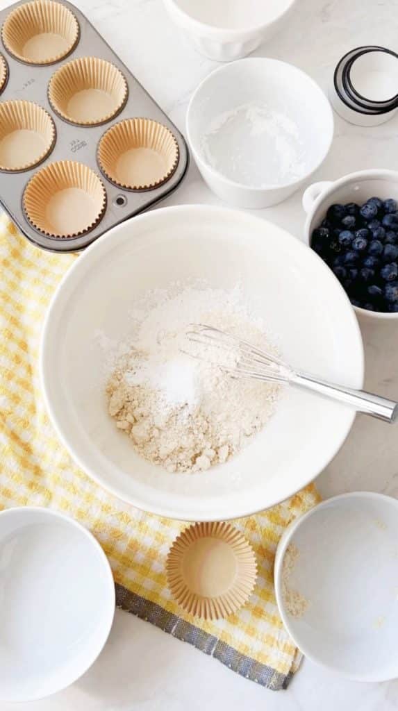 gluten free flours in a white bowl with a whisk