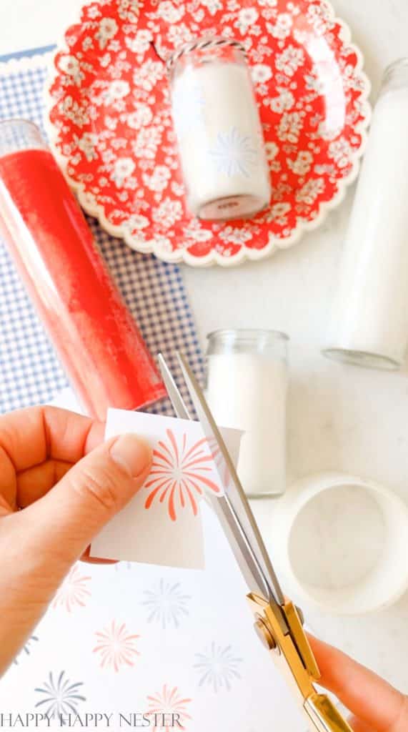 Cutting out of a red starburst image with scissors for the DIY Glass Candle Holder Decoration project