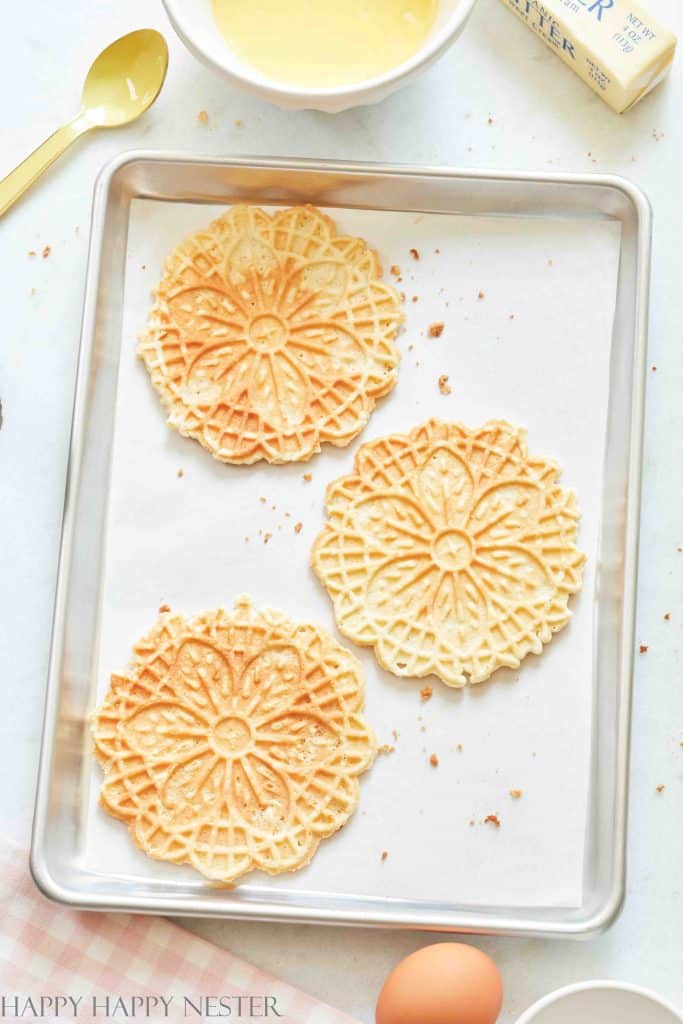 3 Gluten-free pizzelles on a baking tray lined with parchment paper