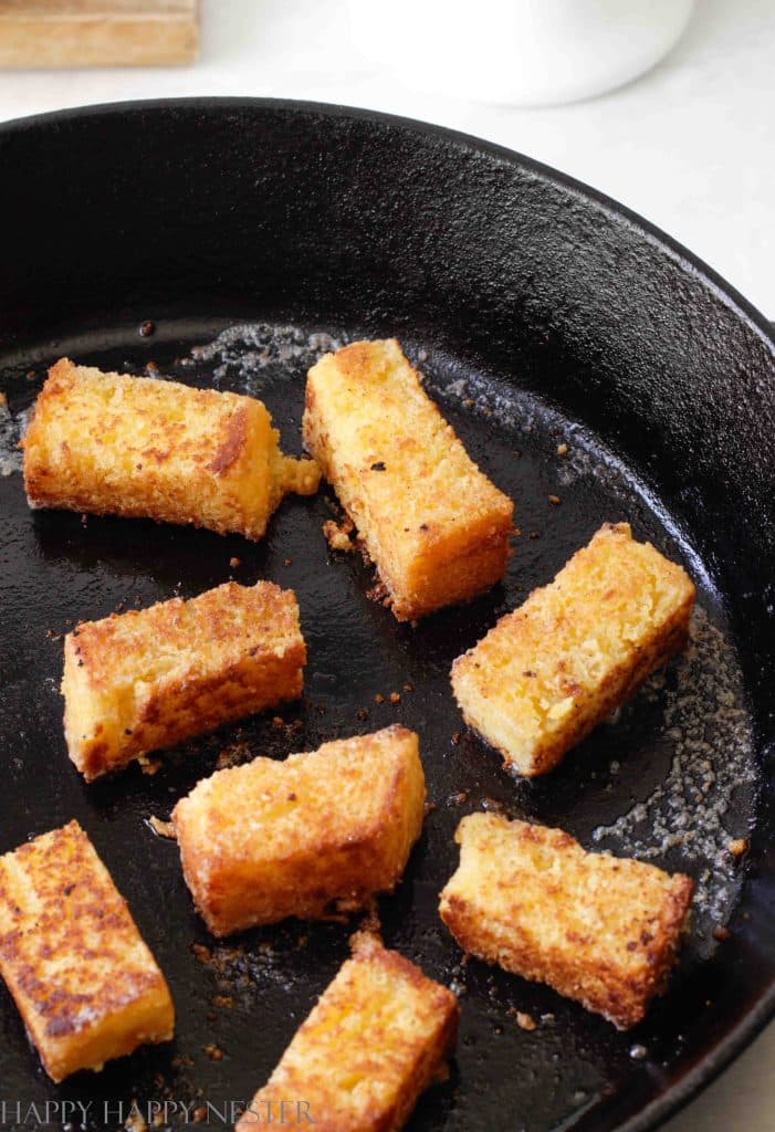 cornbread sticks in a cast iron pan with melted butter