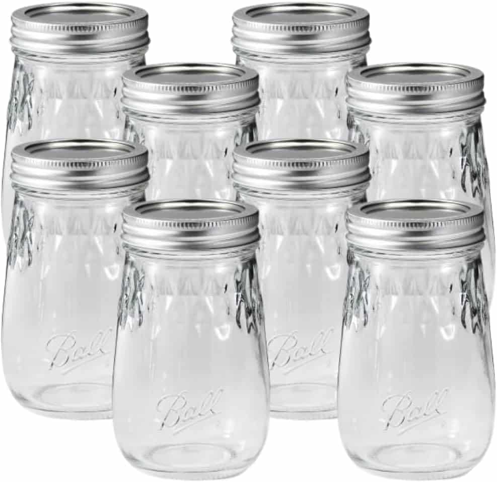 Eight clear glass Ball mason jars with silver lids are arranged in two rows. Perfect for your next recipe for raspberry freezer jam, these empty jars feature the classic Ball logo embossed on the front.