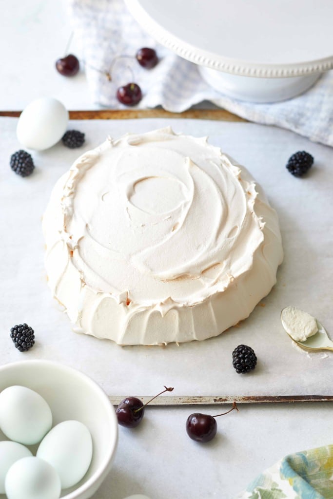 a baked pavlova on a parchment lined baking tray