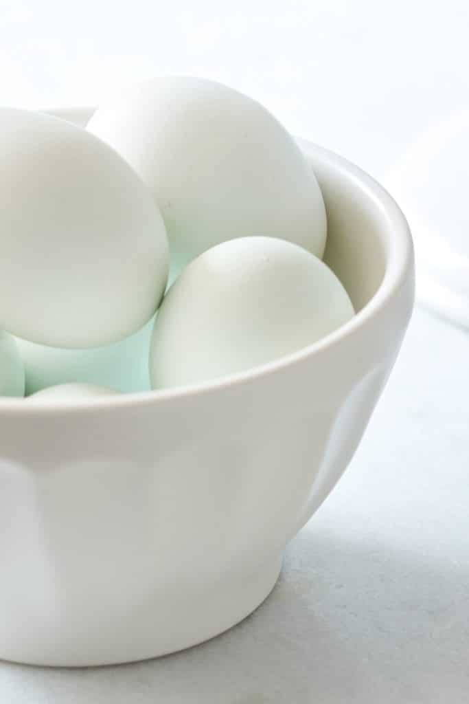 Blue eggs sitting in a white bowl ready to be used to make the classic pavlova recipe