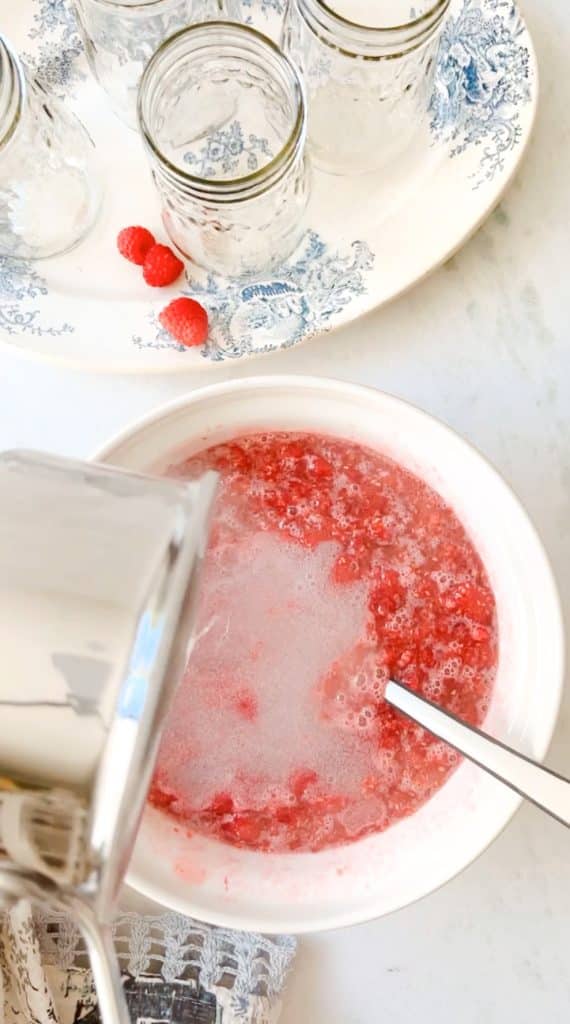 How to make this recipe for raspberry freezer jam. This step show adding the cooked pectin to the fruit and sugar mixture. 