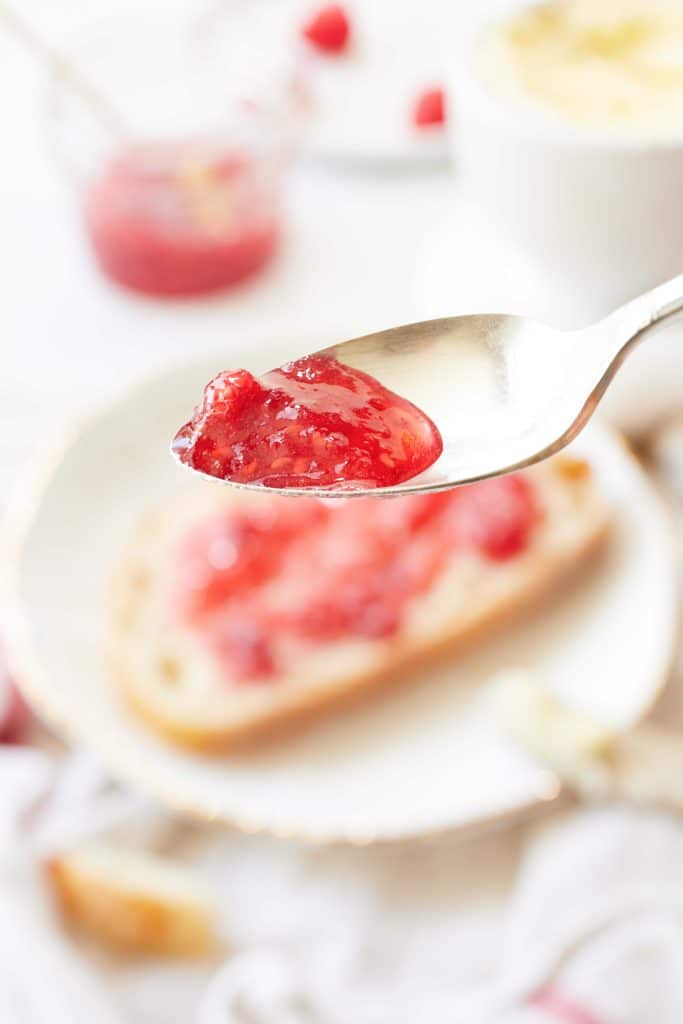 The final results of making this recipe for raspberry freezer jam. This photo shows a spoonful of the jam close up!