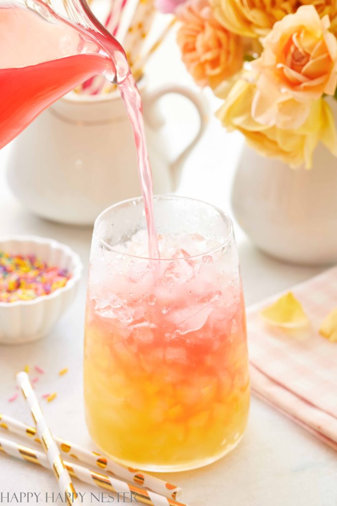 Pouring cranberry watermelon juice into a glass with crushed ice and pineapple juice. 