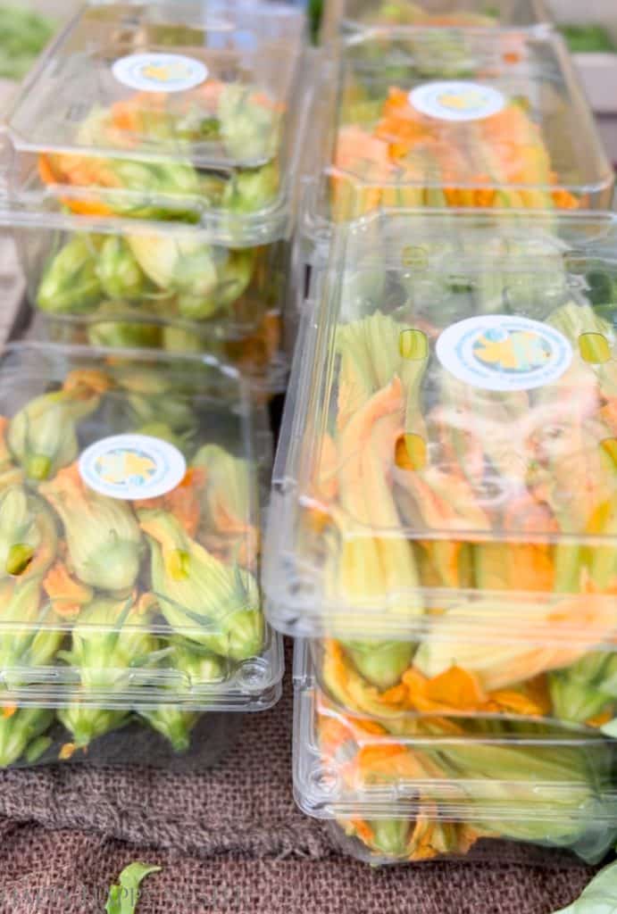 zucchini blossom in packages and for sale at a farmer's market