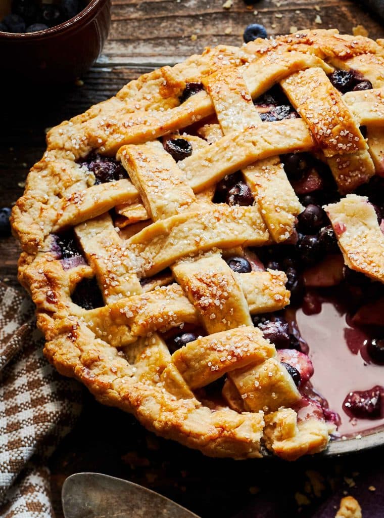 a close up of a whole apple blueberry pie