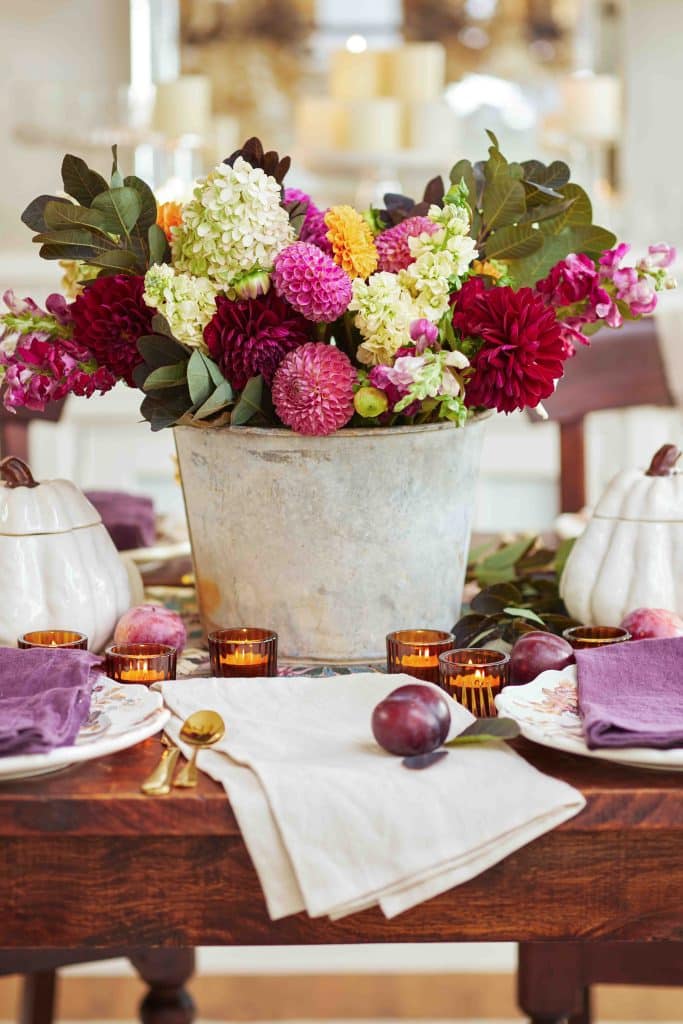 A gorgeous bouquet of burgundy dahlias with pink snapdragons all in an old rusted pail 