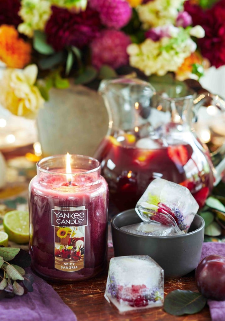 Yankee candle fall spicy sangria scented candle next to a pitcher of sangria and fruit