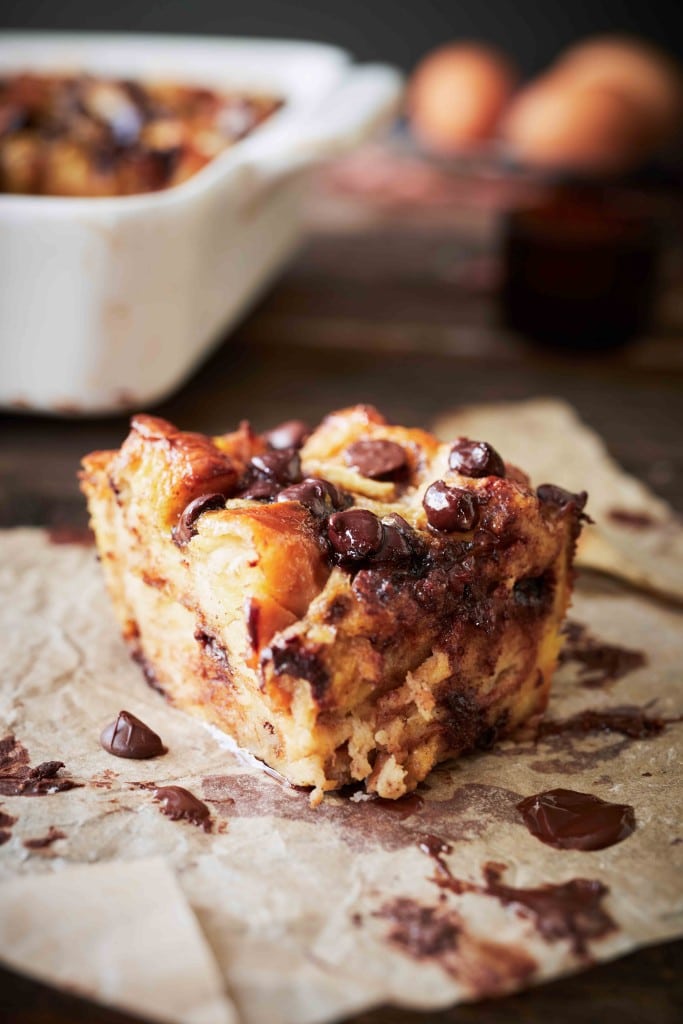 a single slice of chocolate chip banana bread pudding sitting on a sheet of brown parchment paper