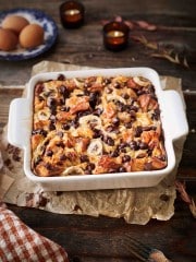 A white pan full of bread pudding with chocolate chips sprinkled over the dessert