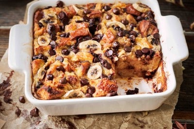 Bread pudding in a white pan on a wooden table