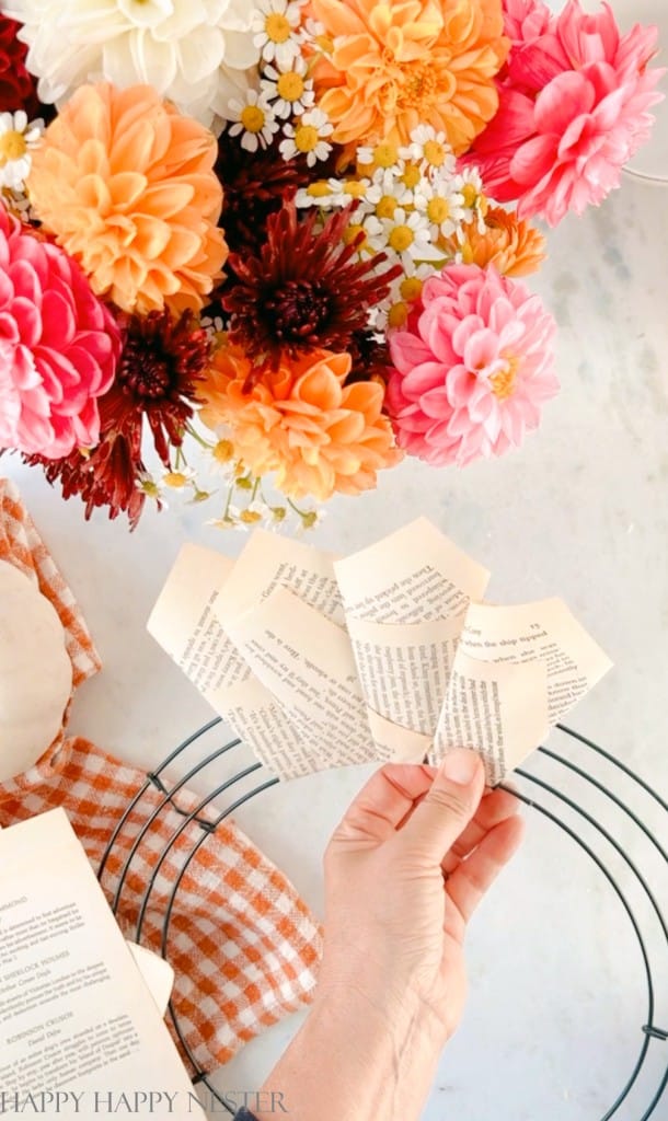 showing how to attach paper cones to this book wreath