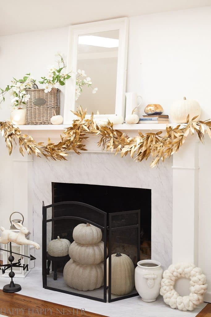white mantel with a gold leaf garland hanging on it.