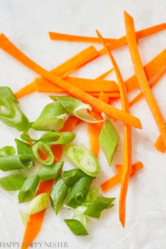 a closeup of carrots and green onion