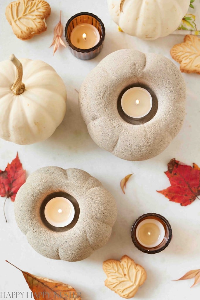 two cement pumpkins with candles burning in them