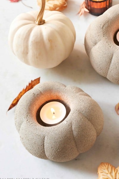 a close up of a candle holder made out cement and shaped like a pumpkin