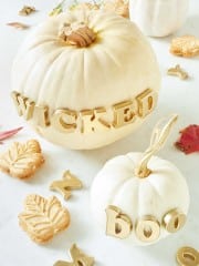 Two white pumpkins that have the words boo and wicked on them