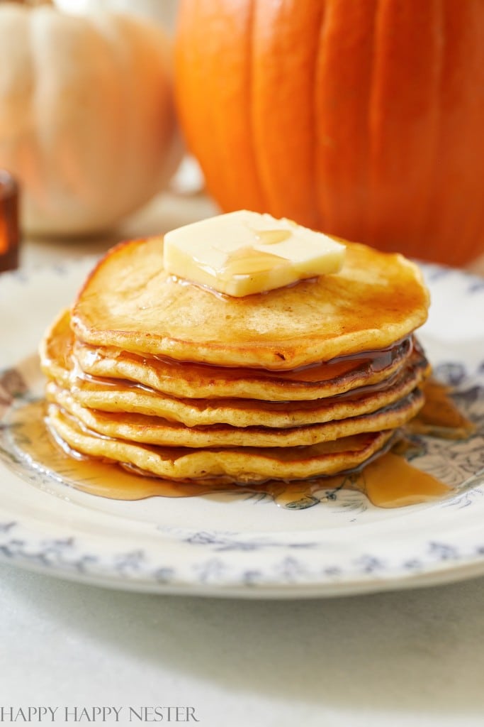 Pumpkin pancakes stacked with a pat of butter and syrup on top