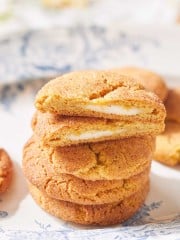 a closeup of a stack of pumpkin cheesecake cookies on a blue french plate