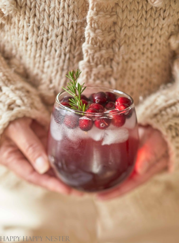 holding a cranberry pineapple punch in a round glass