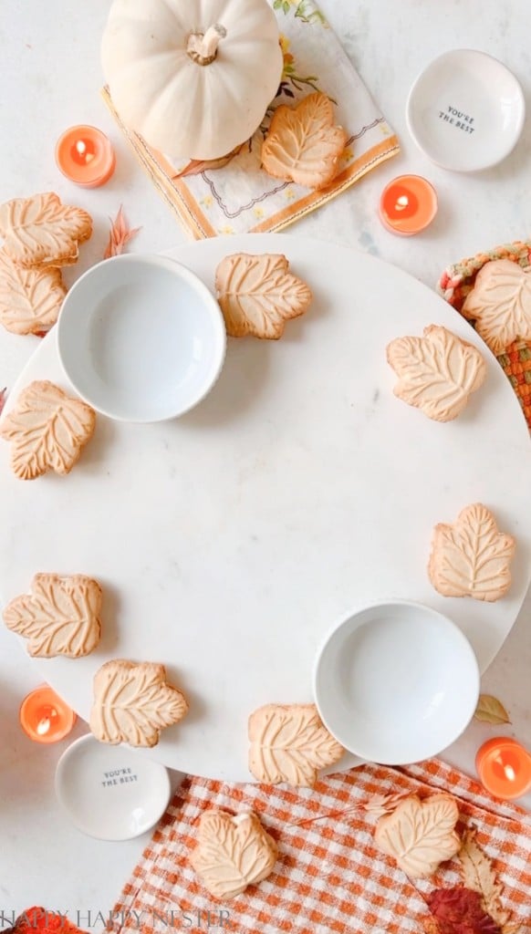 Placing the leaf shaped cookies on a wreath charcuterie board