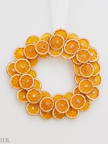 Christmas wreath with orange slices on a white wall