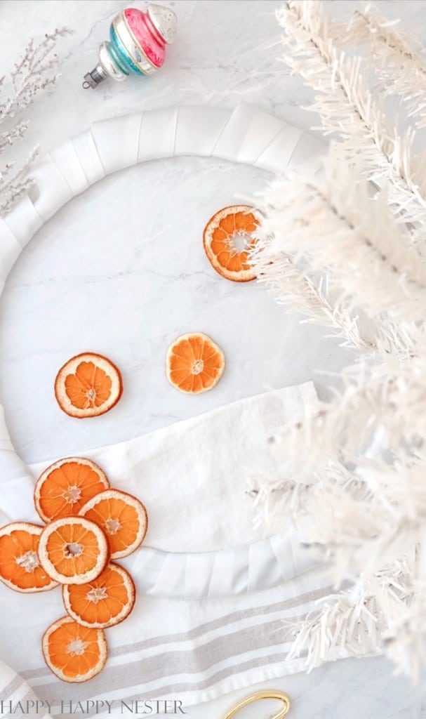 a wreath wrapped in white ribbon ready to attach dried orange slices