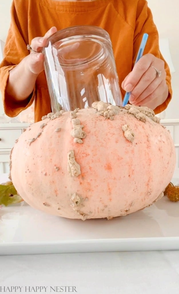 outline the base of a vase at the top of a pumpkin. This outline will be where we will cut the hole for the vase of flowers