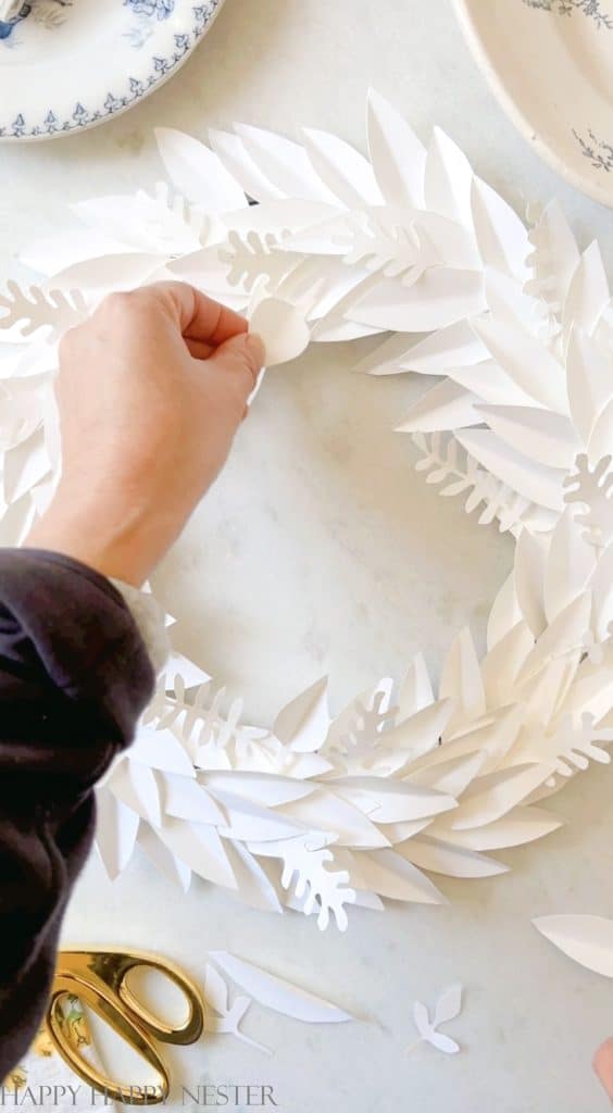 showing how to make a january winter wreath made out of white paper leaves