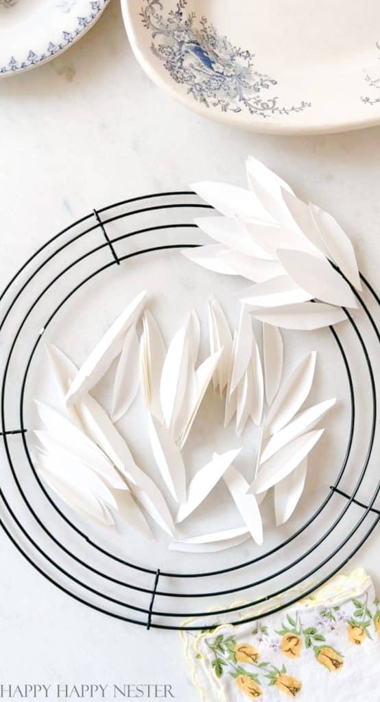a tutorial showing how to attach the white paper leaves to a wire wreath form. 
