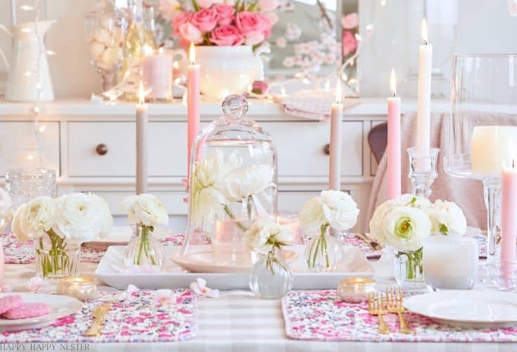 a pink and white valentine's table decor with candles and white flowers