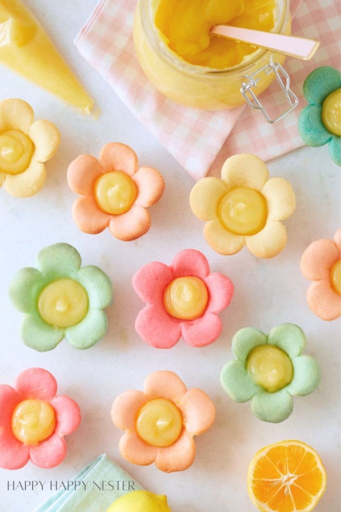 a bunch of colorful flower tartlettes with lemon curd in the centers