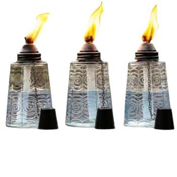 Three decorative glass oil lamps with patterned surfaces, metal tops, and bright orange flames—an amazon find perfect for simple porch decor. Each lamp features a black snuffer cap on a small chain hanging at the side.