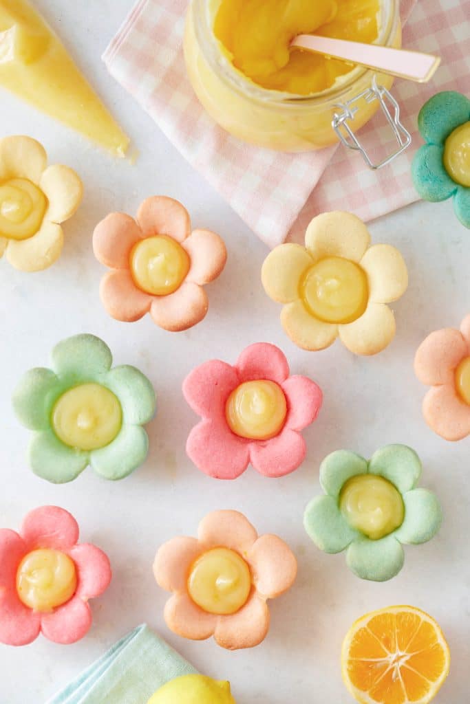 little flower cookies with a dollop of lemon curd in the middle. All the flowers are different colors.