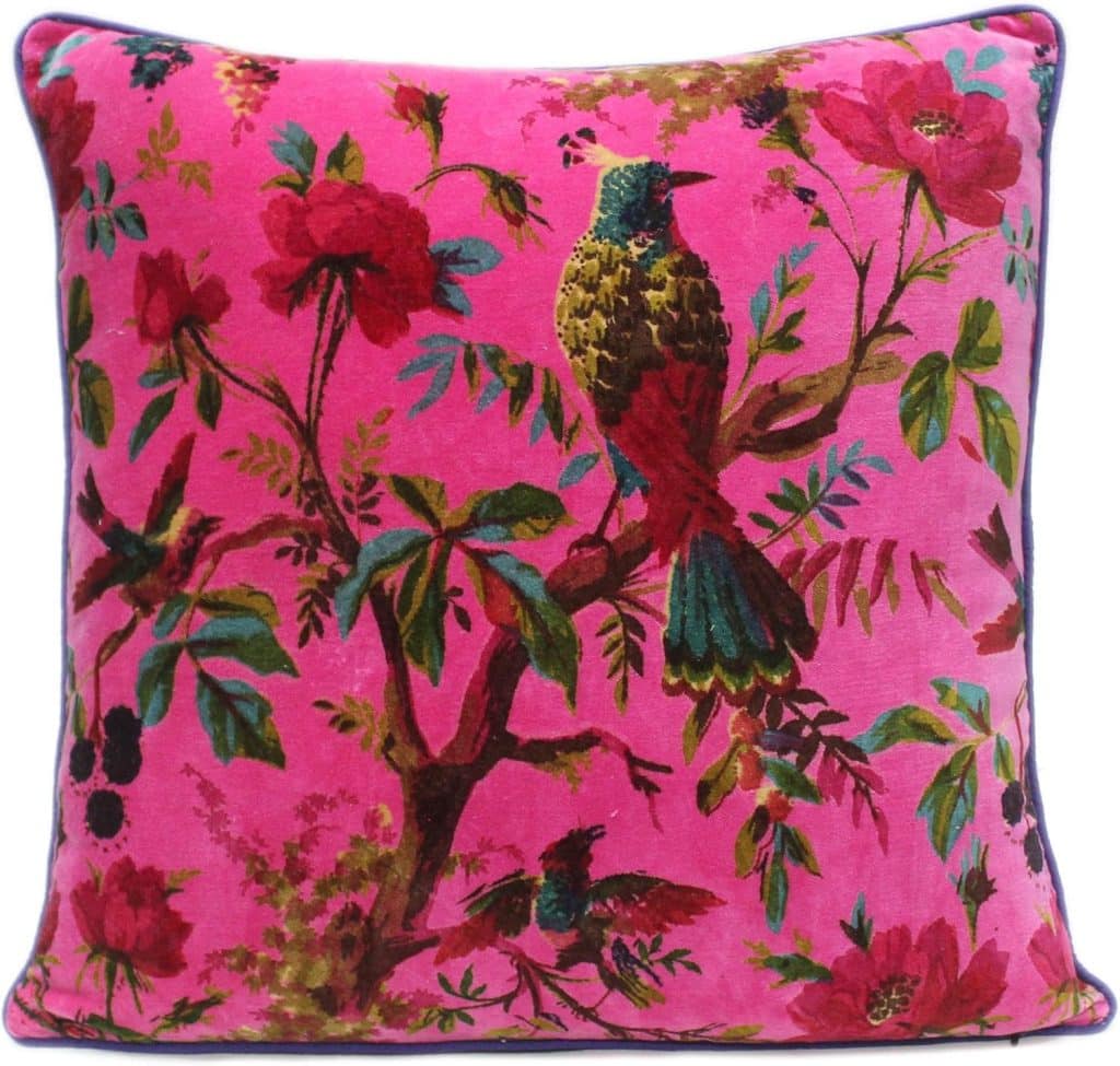 A square amazon boho throw pillow with a vibrant pink background, featuring a colorful bird perched on a tree branch surrounded by green leaves and large red flowers.