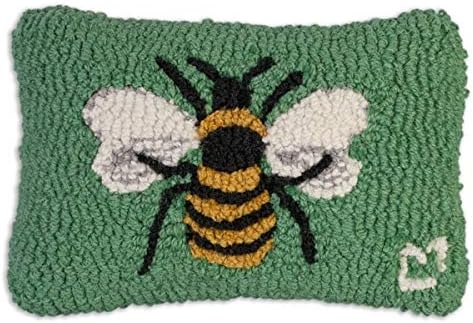 A rectangular green cushion, perfect among springtime throw pillows, features a hooked design of a yellow and black bee with white wings in the center and a small white heart in the bottom right corner.